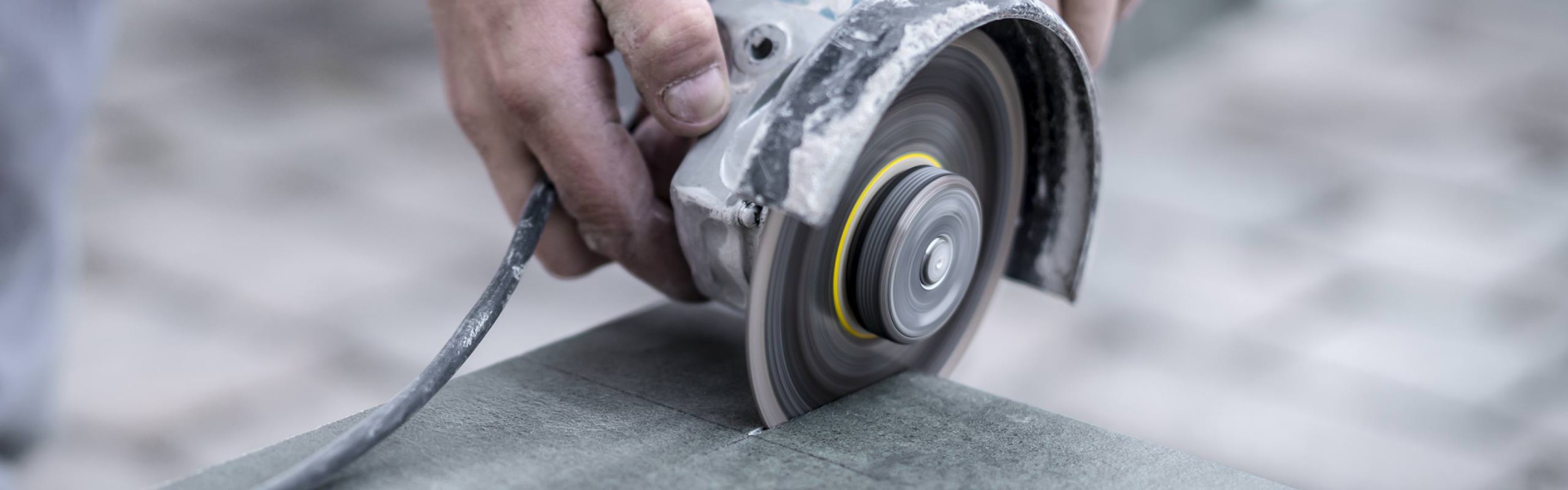 Samuel Gautschi schneidet Steinplatten mit der Trennscheibe
